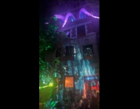 Men wearing alien costume swinging on building wall 