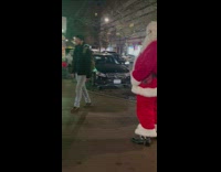 Santa and elf turn on sidewalk 