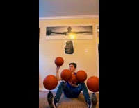 Boy spins and balances six ball on his body in the room