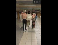 four guys carry a white couch down subway station