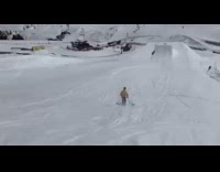 Skier yellow shirt back flips off ramp jumps two more ramps