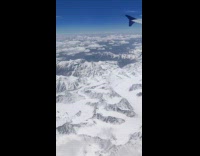 Collab DailyDoseOfInternet - Plane ride view over snowy Himalayas mountain