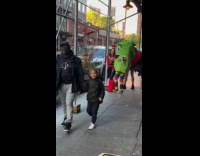 Three people Halloween costume walks on sidewalk