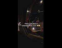 Dog peeks out of driver window and driver covers dog face