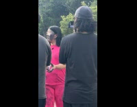 Two women films black sand at park