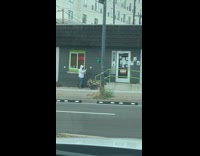 Guy squats steps grey medical building entrance 