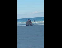 Couple using tripod on beach self timer