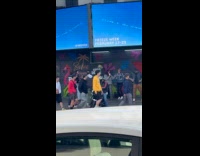 Three women karaoke for video on sidewalk