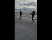 Man walks and stands on the cemented ocean dock