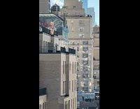 Man on rooftop bouncing on trampoline