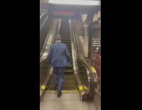 Man blue suit run up escalator subway