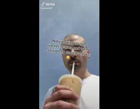 Guy walking with iced coffee on sidewalk white shirt