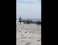 Couple pose on mossy rocks beach wave