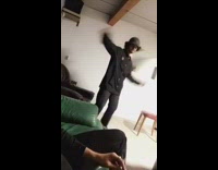 Guy does flip dancing to music and lands on couch falls to floor friend smoking