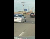 Silver car with tilted wheels on road