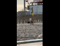 Woman white top dances beside beach pole