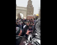 Crowd of people gathered in snow covered park cheering