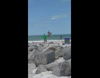 Woman silver onesie spin on pole beach