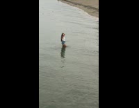 Denim shorts girl stands in beach water