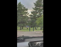 Woman in jumper outfit hugs dog at the park