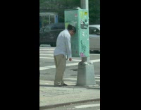 Man leans head on green electric box