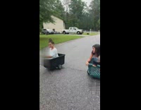 Two girls sit in baskets on hoverboards and race