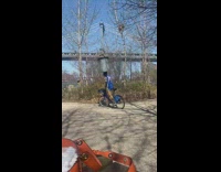 Guy balances full metal trash can on head 