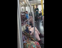 Old man wears patterned ornate design outfit and hat on subway train