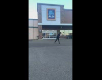 Guy dances in front of stores restaurants 