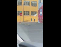 Blue pants guy dances by yellow building 