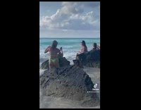 Girl bikini pose beside rock pushed down