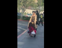 Woman tan coat pictures waiting for valet