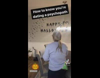 Woman listens to Christmas music putting up Halloween decorations