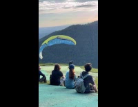 Man run off cliff glides with parachute