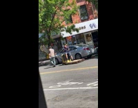 Collab WINY - Man black cap and khaki vest pulls trolley with man on street