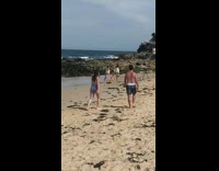 Two woman hula hoop spin tricks beach