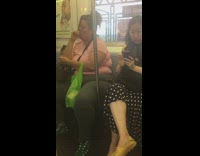 Woman pink shirt sucks her thumb and takes away bag from little girl on subway train