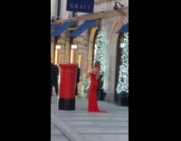 Woman red dress beside mailbox christmas lights