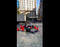 Man playing trombone with buckets on feet