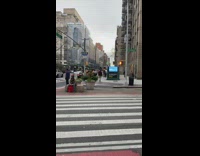 Santa rides red platform cart down street 