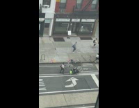 Guy pushes big wheel down street 