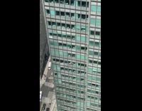Worker cleans window from high floor 