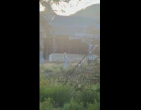 Woman white crop top sweater poses near parking lot 