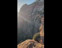 Lady in black dress models on rock at park 