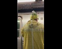 Guy waits for train with iguana sitting on top of head at subway station