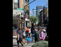 Guy standing by road balances metal trash can 