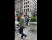 Guy in Donald Trump costume greets pedestrians 