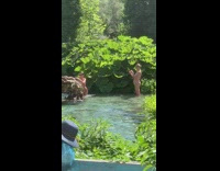 Woman in pink bikini poses beside the rock