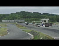 White helmet guy drives black car racetrack 