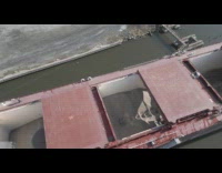 Front loader unloads gravel inside freight video